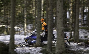 Moottorikelkalla Kalle Martikainen kuljettaa kerrallaan noin kuution kuorman. (Kuvaaja: Ari Komulainen)