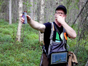 Lauri Karvonen mittaa pysty- ja maalahopuun kuutiomäärää koealalta relaskoopilla. (Kuvaaja: Kari Lindholm)