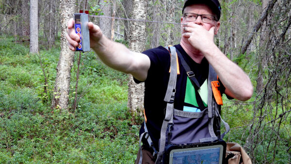 Lauri Karvonen mittaa pysty- ja maalahopuun kuutiomäärää koealalta relaskoopilla. (Kuvaaja: Kari Lindholm)